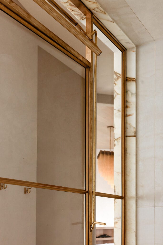 Lined in dramatic Calacatta marble, with a matching storage alcove and marble bench